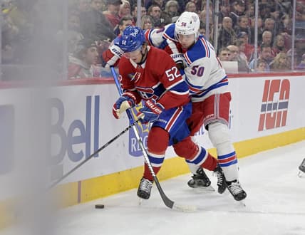 Jan 6, 2024; Montreal, Quebec, CAN; Montreal Canadiens defenseman Justin Barron (52) plays the puck and New York Rangers forward Will Cuylle (50) forechecks during the first period at the Bell Centre. Mandatory Credit: Eric Bolte-USA TODAY Sports