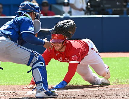 Jul 16, 2022; Toronto, Ontario, CAN;  Toronto Blue Jays catcher Danny Jansen (9) slides to score past Kansas City Royals catcher Freddy Fermin (78) in the third inning at Rogers Centre. Mandatory Credit: Dan Hamilton-USA TODAY Sports