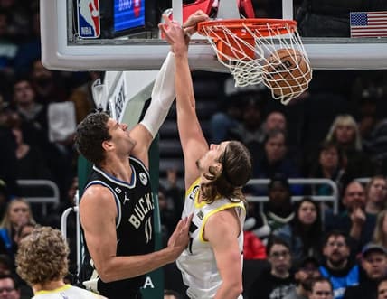 Dec 17, 2022; Milwaukee, Wisconsin, USA; Milwaukee Bucks center Brook Lopez (11)  dunks against Utah Jazz guard Mike Conley (11) in the first quarter at Fiserv Forum. Mandatory Credit: Benny Sieu-USA TODAY Sports