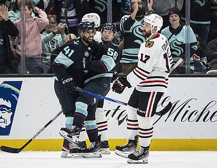 Dec 14, 2023; Seattle, Washington, USA; Seattle Kraken forward Kailer Yamamoto (56) celebrates with forward Pierre-Edouard Bellemare (41) in front of Chicago Blackhawks forward Nick Foligno (17) after scoring a goal during the first period at Climate Pledge Arena. Mandatory Credit: Stephen Brashear-USA TODAY Sports
