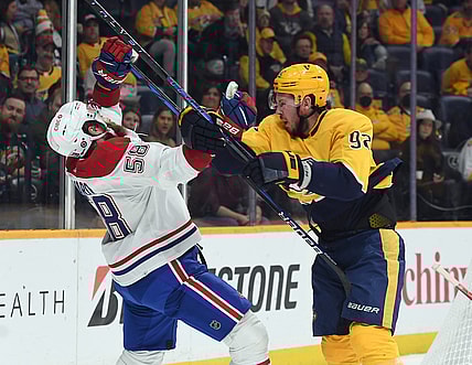 Dec 4, 2021; Nashville, Tennessee, USA; Nashville Predators center Ryan Johansen (92) is called for a high stick after a hit on Montreal Canadiens defenseman David Savard (58) during the first period at Bridgestone Arena. Mandatory Credit: Christopher Hanewinckel-USA TODAY Sports