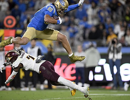 Nov 11, 2023; Pasadena, California, USA;  UCLA Bruins tight end Moliki Matavao (88) leaps over Arizona State Sun Devils defensive back Shamari Simmons (7) after making a catch during the first half at the Rose Bowl. Mandatory Credit: Alex Gallardo-USA TODAY Sports