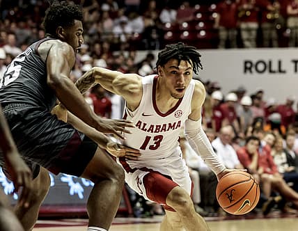 Mar 2, 2022; Tuscaloosa, Alabama, USA; Alabama Crimson Tide guard Jahvon Quinerly (13) dribbles around Texas A&M Aggies forward Henry Coleman III (15) during the second half at Coleman Coliseum. Mandatory Credit: Butch Dill-USA TODAY Sports