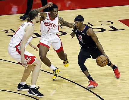 May 14, 2021; Houston, Texas, USA; LA Clippers guard Rajon Rondo (4) drives against Houston Rockets guard Armoni Brooks (7) and forward Kelly Olynyk (41) during the second quarter at Toyota Center. Mandatory Credit:  Bob Levey/Pool Photo-USA TODAY Sports