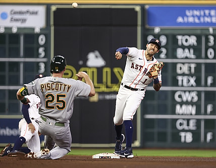 Jul 7, 2021; Houston, Texas, USA; Oakland Athletics right fielder Stephen Piscotty (25) is forced out at second base as Houston Astros shortstop Carlos Correa (1) throws to first base during the fifth inning at Minute Maid Park. Mandatory Credit: Troy Taormina-USA TODAY Sports