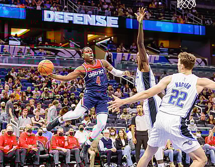 Nov 13, 2021; Orlando, Florida, USA; Washington Wizards guard Aaron Holiday (4) passes the ball in front of Orlando Magic center Mo Bamba (center) and forward Franz Wagner (22) during the first quarter at Amway Center. Mandatory Credit: Mike Watters-USA TODAY Sports