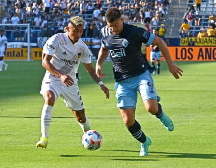 Aug 8, 2021; Carson, California, USA;  Los Angeles Galaxy defender Julian Araujo (2) guards Vancouver Whitecaps forward Lucas Cavallini (9) as he takes the ball toward the goal in the first half of the game at Dignity Health Sports Park Center. Mandatory Credit: Jayne Kamin-Oncea-USA TODAY Sports