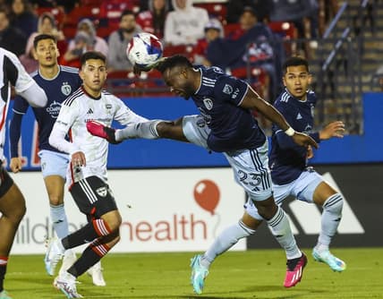 Mar 18, 2023; Frisco, Texas, USA;  Sporting Kansas City forward Willy Agada (23) heads the ball away from FC Dallas forward Alan Velasco (20) during the match at Toyota Stadium. Mandatory Credit: Kevin Jairaj-USA TODAY Sports