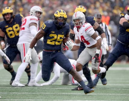 Michigan Wolverines running back Hassan Haskins runs by Ohio State Buckeyes safety Ronnie Hickman during the first half Saturday, Nov. 27, 2021, Michigan Stadium.

Michigan Ohio