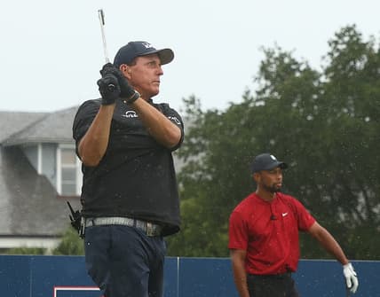 May 24, 2020; Hobe Sound, FL, USA; Phil Mickelson plays his shot from the first tee as Tiger Woods looks on during The Match: Champions for Charity golf round at the Medalist Golf Club.  Mandatory Credit: Handout Photo by Getty Images for The Match via USA TODAY Sports