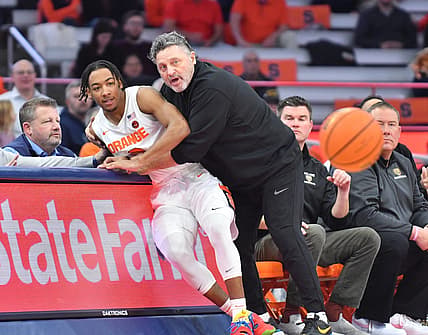 Dec 6, 2022; Syracuse, New York, USA; Syracuse Orange guard Judah Mintz (3) is caught by Oakland Golden Grizzlies head coach Greg Kampe after going off court for a loose ball in the first half at JMA Wireless Dome. Mandatory Credit: Mark Konezny-USA TODAY Sports