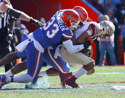 Florida State Seminoles quarterback Jordan Travis (13) is tackles by Florida Gators defenders during a game at Ben Hill Griffin Stadium in Gainesville Fla., Nov. 27, 2021.

Flagi 112721 Ufvfsu Fb 06