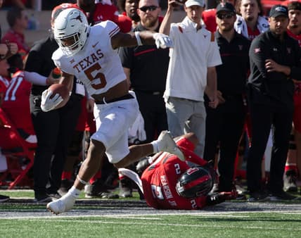 Texas' running back Bijan Robinson (5), left, runs with the ball against Texas Tech, Saturday, Sept. 24, 2022, at Jones AT&T Stadium. Texas Tech won, 37-34 in overtime.