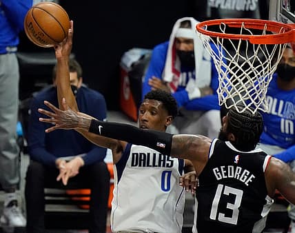 May 22, 2021; Los Angeles, California, USA; Dallas Mavericks guard Josh Richardson (0) hangs in the air as he passes off top a teammate as LA Clippers guard Paul George (13) defends in the second quarter of game one in the first round of the 2021 NBA Playoffs at Staples Center. Mandatory Credit: Robert Hanashiro-USA TODAY Sports