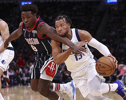 Jan 7, 2022; Houston, Texas, USA; Dallas Mavericks guard Jalen Brunson (13) attempts to drive the ball around Houston Rockets forward Jae'Sean Tate (8) during the third quarter at Toyota Center. Mandatory Credit: Troy Taormina-USA TODAY Sports