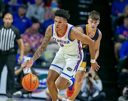 Florida Gators guard Will Richard (5) steals the ball from Merrimack College Jordan Derkack (4) during first half action of an NCAA basketball game as Florida Gators take on Merrimack College Warrors at Exactech Areana in Gainesville, FL on Tuesday, December 5, 2023. [Alan Youngblood/Gainesville Sun]