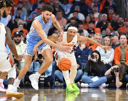 Jan 24, 2023; Syracuse, New York, USA; Syracuse Orange forward Benny Williams (13) and North Carolina Tar Heels forward Pete Nance (32) go for a loose ball in the first half at JMA Wireless Dome. Mandatory Credit: Mark Konezny-USA TODAY Sports