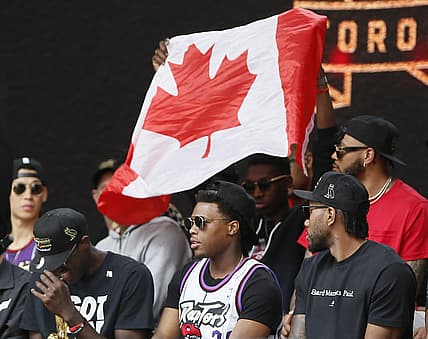 Jun 17, 2019; Toronto, Ontario, Canada; A Canadian flag is held behind Toronto Raptors guard Kyle Lowry (7) during a rally at Nathan Phillips Square. Mandatory Credit: John E. Sokolowski-USA TODAY Sports