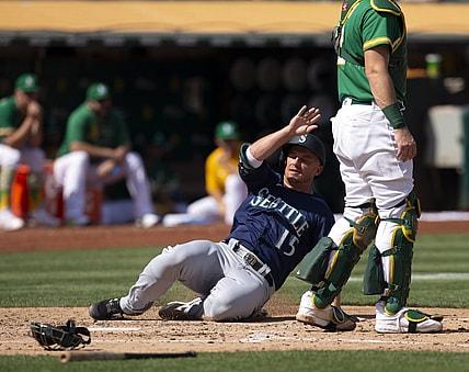 Sep 23, 2021; Oakland, California, USA; Seattle Mariners designated hitter Kyle Seager (15) slides safely home on an RBI double by Abraham Toro during the fourth inning against the Oakland Athletics at RingCentral Coliseum. Mandatory Credit: D. Ross Cameron-USA TODAY Sports