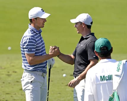 Apr 5, 2021; Augusta, Georgia, USA; Rory McIlroy congratulates Jordan Spieth (left) after winning the Valero Texas Open yesterday as they prepare for The Masters golf tournament at Augusta National Golf Club. Mandatory Credit: Rob Schumacher-USA TODAY Sports