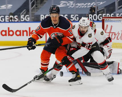 Feb 2, 2021; Edmonton, Alberta, CAN; Edmonton Oilers forward Jesse Puljujarvi (13) and Ottawa Senators forward Cedric Paquette (23) look for a loose puck during the first period at Rogers Place. Mandatory Credit: Perry Nelson-USA TODAY Sports