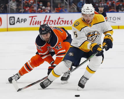 Nov 3, 2021; Edmonton, Alberta, CAN; Nashville Predators defensemen Matt Benning (5) moves the puck in front of Edmonton Oilers forward Brendan Perlini (42) during the first period at Rogers Place. Mandatory Credit: Perry Nelson-USA TODAY Sports