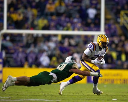 Nov 19, 2022; Baton Rouge, Louisiana, USA;  LSU Tigers running back Noah Cain (21) rushes against UAB Blazers linebacker Noah Wilder (50) during the first half at Tiger Stadium. Mandatory Credit: Stephen Lew-USA TODAY Sports