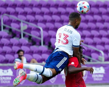 Apr 24, 2021; Orlando, Florida, USA; Vancouver Whitecaps defender Derek Cornelius (13) and Toronto FC forward Ayo Akinola (20) fight for the ball during the second half at Orlando City Stadium. Mandatory Credit: Douglas DeFelice-USA TODAY Sports