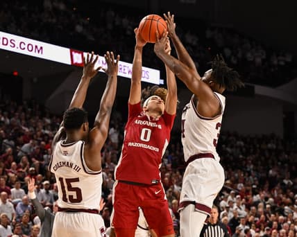 Feb 15, 2023; College Station, Texas, USA;Arkansas Razorbacks guard Anthony Black (0) looks to shoot over Texas A&M Aggies forward Henry Coleman III (15) and forward Julius Marble (34) during the first half at Reed Arena. Mandatory Credit: Maria Lysaker-USA TODAY Sports