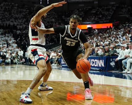 Feb 22, 2023; Storrs, Connecticut, USA; Providence Friars forward Bryce Hopkins (23) dribbles the ball against Connecticut Huskies guard Nahiem Alleyne (4) during the first half at Harry A. Gampel Pavilion. Mandatory Credit: Gregory Fisher-USA TODAY Sports