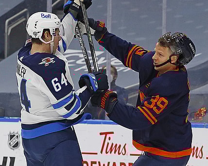 May 21, 2021; Edmonton, Alberta, CAN; Winnipeg Jets defensemen Logan Stanley (64) and Edmonton Oilers forward Alex Chiasson (39) battle for position during the first period in game two of the first round of the 2021 Stanley Cup Playoffs at Rogers Place. Mandatory Credit: Perry Nelson-USA TODAY Sports