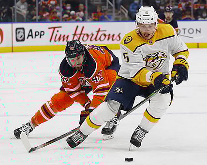 Nov 3, 2021; Edmonton, Alberta, CAN; Nashville Predators defensemen Matt Benning (5) moves the puck in front of Edmonton Oilers forward Brendan Perlini (42) during the first period at Rogers Place. Mandatory Credit: Perry Nelson-USA TODAY Sports
