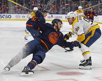 Jan 27, 2022; Edmonton, Alberta, CAN; /n90- trips up Edmonton Oilers forward Connor McDavid (97) during the third period at Rogers Place. Mandatory Credit: Perry Nelson-USA TODAY Sports