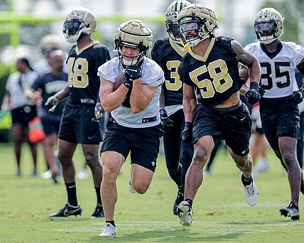 Jul 28, 2022; Metairie, LA, USA;  New Orleans Saints linebacker Eric Wilson (58) attempts to punch the ball from quarterback Taysom Hill (7) during training camp at Ochsner Sports Performance Center. Mandatory Credit: Stephen Lew-USA TODAY Sports