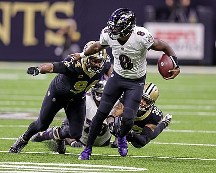 fNov 7, 2022; New Orleans, Louisiana, USA;  Baltimore Ravens quarterback Lamar Jackson (8) scrambles away from New Orleans Saints defensive end Cameron Jordan (94) and safety Tyrann Mathieu (32) during the second half at Caesars Superdome. Mandatory Credit: Stephen Lew-USA TODAY Sports