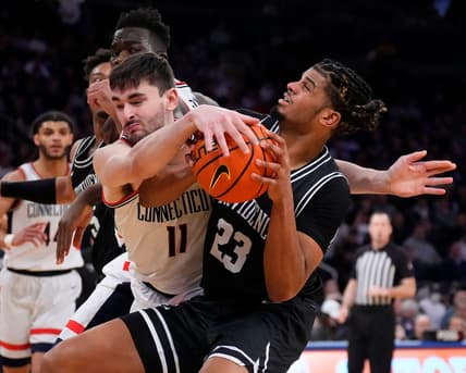 Mar 9, 2023; New York, NY, USA;  Connecticut Huskies forward Alex Karaban (11) ties up Providence Friars forward Bryce Hopkins (23) in the second half at Madison Square Garden. Mandatory Credit: Robert Deutsch-USA TODAY Sports