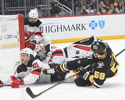 Nov 16, 2023; Pittsburgh, Pennsylvania, USA; Pittsburgh Penguins left wing Jake Guentzel (58) crashes into New Jersey Devils goalie Vitek Vanecek (41) and center Dawson Mercer (91) during the first period at PPG Paints Arena. Mandatory Credit: Philip G. Pavely-USA TODAY Sports