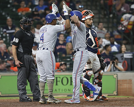 May 16, 2021; Houston, Texas, USA;  Texas Rangers designated hitter Khris Davis (4) celebrates left fielder David Dahl (21) two run home run against the Houston Astros in the seventh inning at Minute Maid Park. Mandatory Credit: Thomas Shea-USA TODAY Sports