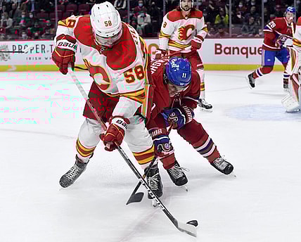 Nov 11, 2021; Montreal, Quebec, CAN; Calgary Flames defenseman Oliver Kylington (58) and Montreal Canadiens forward Brendan Gallagher (11) battle for the puck during the first period at the Bell Centre. Mandatory Credit: Eric Bolte-USA TODAY Sports