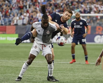 Jun 24, 2023; Foxborough, Massachusetts, USA; Toronto FC forward C.J. Sapong (9) tries to hold off New England Revolution defender Dave Romney (2) during the first half at Gillette Stadium. Mandatory Credit: Winslow Townson-USA TODAY Sports