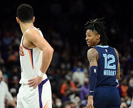 Dec 27, 2021; Phoenix, Arizona, USA; Memphis Grizzlies guard Ja Morant (12) has words with Phoenix Suns guard Devin Booker (1) during the second half at Footprint Center. Mandatory Credit: Joe Camporeale-USA TODAY Sports