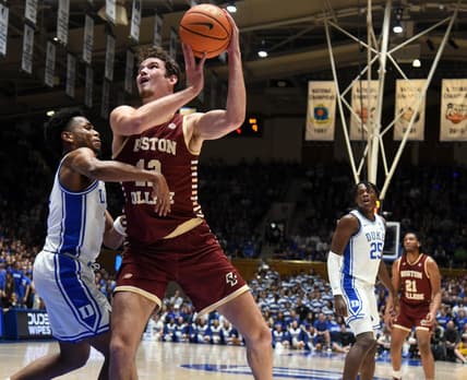 Feb 10, 2024; Durham, North Carolina, USA; Boston College Eagles center Quinten Post (12) shoots the ball over Duke Blue Devils guard Jeremy Roach (left) during the first half  at Cameron Indoor Stadium. Mandatory Credit: Rob Kinnan-USA TODAY Sports