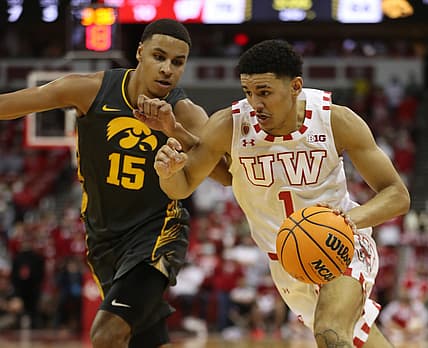 Jan 6, 2022; Madison, Wisconsin, USA; Wisconsin Badgers guard Johnny Davis (1) brings the ball up the floor as Iowa Hawkeyes forward Keegan Murray (15) follows at the Kohl Center. Mandatory Credit: Mary Langenfeld-USA TODAY Sports