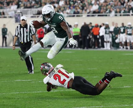 Michigan State Spartans running back Kenneth Walker III jumps over Western Kentucky Hilltoppers defensive back Beanie Bishop on Saturday, Oct. 02, 2021.

Msu Wku