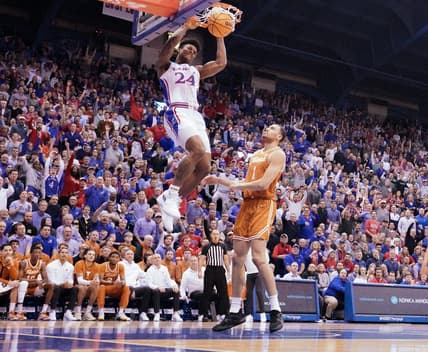 Feb 6, 2023; Lawrence, Kansas, USA; Kansas Jayhawks forward K.J. Adams Jr. (24) dunks the ball as Texas Longhorns forward Dylan Disu (1) looks on during the first half at Allen Fieldhouse. Mandatory Credit: Denny Medley-USA TODAY Sports