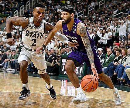 Dec 4, 2022; East Lansing, Michigan, USA; Northwestern Wildcats guard Boo Buie (0) drives the baseline against Michigan State Spartans guard Tyson Walker (2) at Jack Breslin Student Events Center. Mandatory Credit: Dale Young-USA TODAY Sports