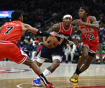 Jan 1, 2022; Washington, District of Columbia, USA; Washington Wizards guard Bradley Beal (3) drives between Chicago Bulls forward Troy Brown Jr. (7) and guard Ayo Dosunmu (12) during the first half at Capital One Arena. Mandatory Credit: Brad Mills-USA TODAY Sports