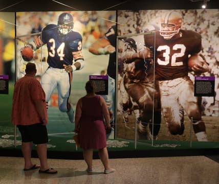 Fans look at the photo display in the HOF museum the Pro Football Hall of Fame Enshrinement ceremony Sunday, Aug. 8, 2021 at Tom Benson Hall of Fame Stadium in Canton, Ohio.

Hof Calvin