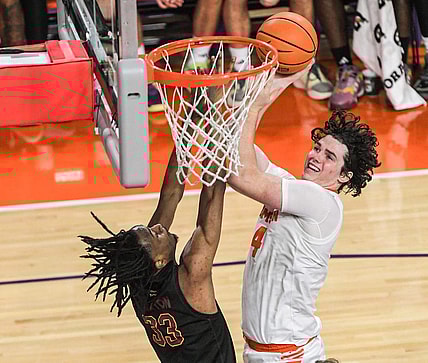 Clemson junior forward Ian Schieffelin (4) scores near Winthrop forward Chase Clayton (33) during the first half at Littlejohn Coliseum in Clemson, S.C. Monday, November 6, 2023.