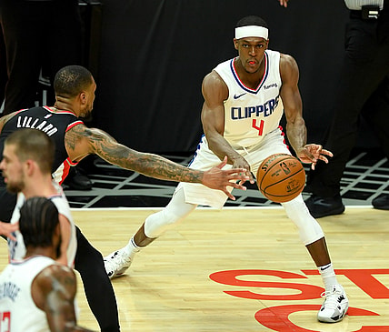 Apr 6, 2021; Los Angeles, California, USA; Los Angeles Clippers guard Rajon Rondo (4) is defended by Portland Trail Blazers guard Damian Lillard (0)as he passes the ball in the first half of the game at Staples Center. Mandatory Credit: Jayne Kamin-Oncea-USA TODAY Sports